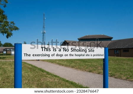 Shallow focus of a generic No Smoking or excising of dogs seen on the campus of an English hospital in summer.