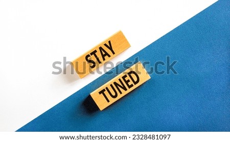 Stay tuned symbol. Concept words Stay tuned on wooden blocks on a beautiful white and blue background. Business, support, motivation, psychological and stay tuned concept. Copy space.