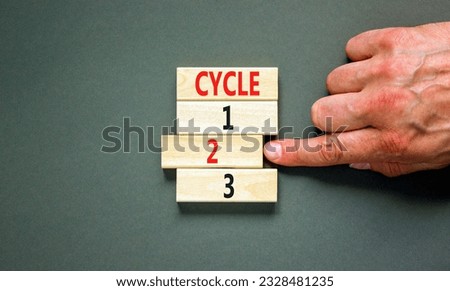 Time to cycle 2 symbol. Concept word Cycle 1 2 3 on wooden block. Businessman hand. Beautiful grey table grey background. Business planning and time to cycle 2 concept. Copy space.