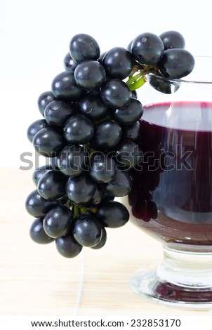 Ripe grapes and wine on white background