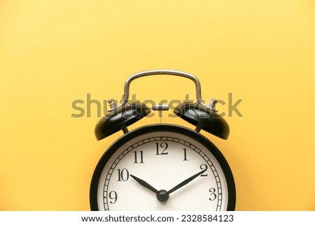 Concept of time, reminder, countdown, alert, deadline. Alarm clock isolated on yellow background.Copy space.