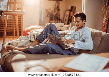 Young man using a laptop at home in the morning at home