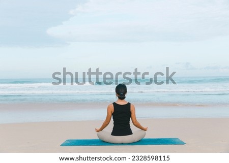A woman gracefully practices yoga at the beach, immersing herself in the tranquil surroundings, finding inner peace and harmony with each pose.