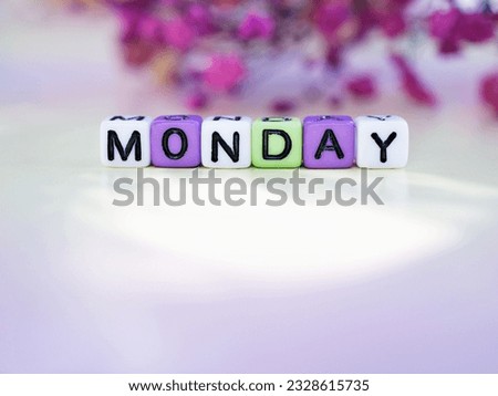 Monday alphabet letters with blurred purple flowers