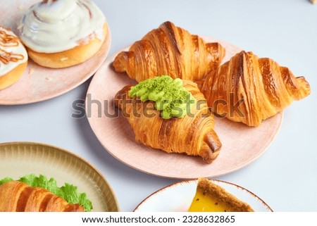 Crispy french croissants on a pink plate on a white background