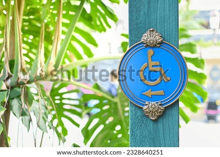 A beautiful blue handicapped sign attached to a green wooden pole. on natural background