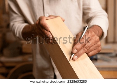 Carpenter working on woodworking tools in carpentry shop. person works in a carpentry shop. woodworker. woodcutting. Royalty-Free Stock Photo #2328653285