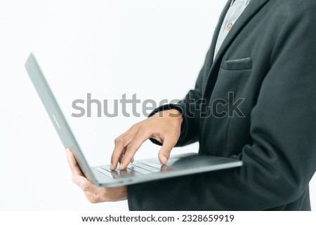 Businessman in half black suit standing left hand holding laptop The right hand is about to touch the keyboard. Business work on white background.