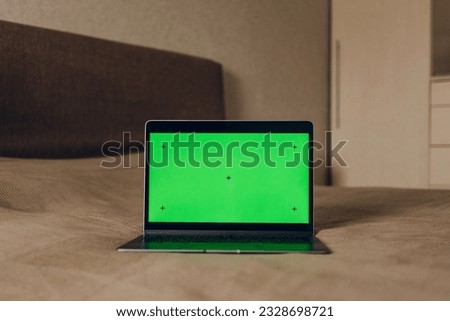 The laptop is on the bed. Green screen laptop