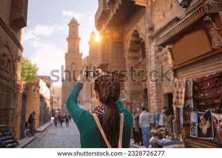 A young girl takes pictures in one of the neighborhoods of Cairo, Egypt