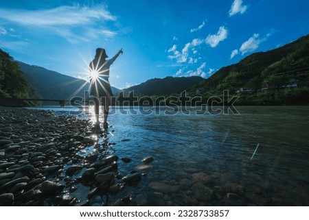 A woman pointing at the Shimanto River