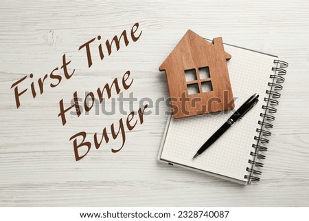 First time home buyer. House figure, pen and notebook on white wooden table, top view Royalty-Free Stock Photo #2328740087