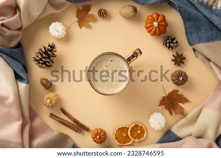 Feel the warmth of covering in soft knitted blanket with a cup of hot drink at home in autumn with this above view photo with autumnal decorations on beige isolated background