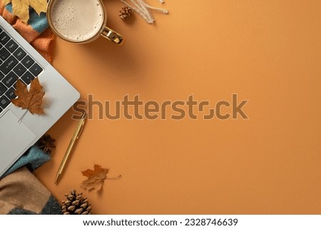 Bird's eye top view of autumnal freelance workstation, complete with a laptop, gilded pen, coffee mug, scarf and charming autumnal decorations on brown background. Perfect for text or advert placement Royalty-Free Stock Photo #2328746639