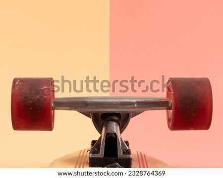 Skateboard on a pink and orange background. Skateboard close up.