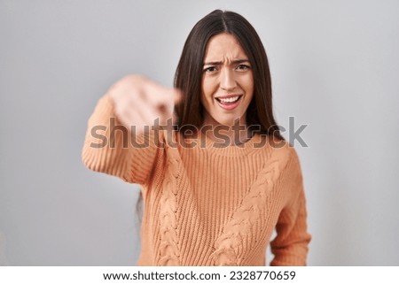 Young brunette woman standing over white background pointing displeased and frustrated to the camera, angry and furious with you  Royalty-Free Stock Photo #2328770659