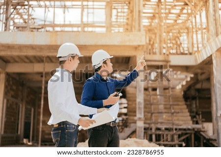 half body photo 2 Asian male engineers are master technicians and supervisors. pointing to the construction site about the architecture industry Wear a helmet, uniform, have a radio, blueprint