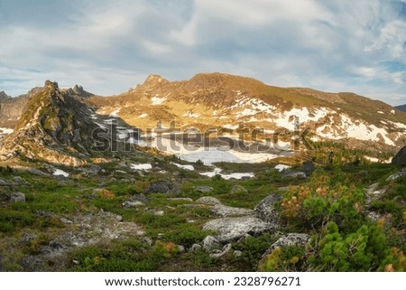 Minimalistic beautiful mountain scenery with golden light on snow slopes mountains. Scenic mountain landscape with illuminating color in blue sky. Western Sayan.  Royalty-Free Stock Photo #2328796271