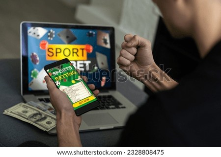 Man watching football play online broadcast on his laptop, cheering for his favourite team, making bets at bookmaker's website