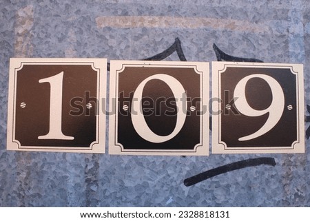 Printed numbers attached to a metal door 109