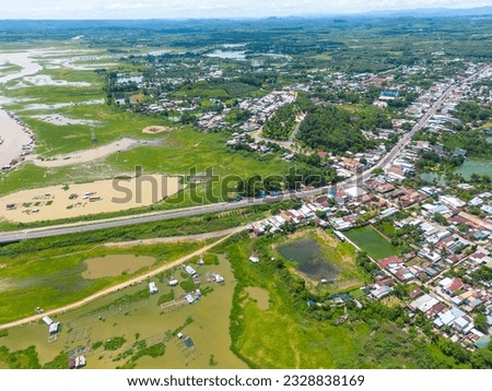 Aerial view of National Route 20 in Dong Nai province, group of floating house on La Nga river, Vietnam with hilly landscape and sparse population around the roads. Travel and landscape concept.