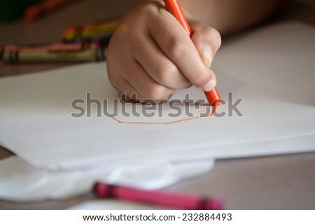 Detail of child coloring on blank white paper with color crayons