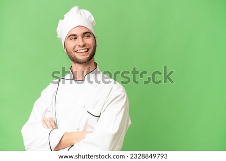 Young handsome chef man over isolated background with arms crossed and happy