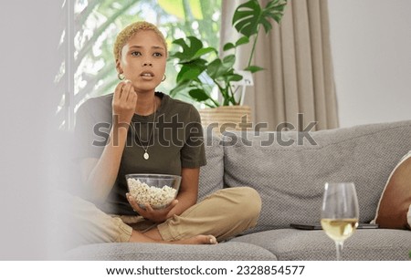Woman, popcorn and watch a movie, streaming online with service and relax at home on sofa. Female person, subscription and internet, watching drama film or series with cinema snack and television