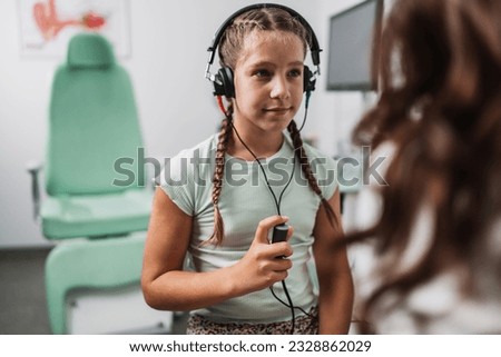 Audiologist doing impedance audiometry or diagnosis of hearing impairment. An beautiful teenage girl getting an auditory test at a hearing clinic. Healthcare and medicine concept. Royalty-Free Stock Photo #2328862029