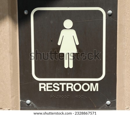 A close view of the brown restroom sign.