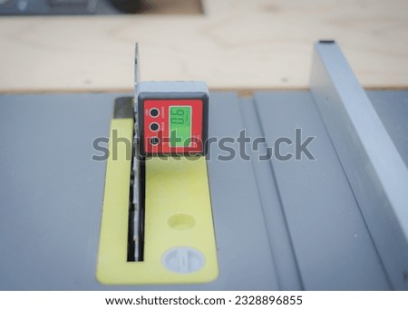 9-degree angle level calibration on digital level box inclinometer attaches to steel blade of brand-new table saw on magnetic base. Protractor bevel gauge absolute measurements woodworking carpentry