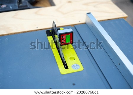 0-degree angle level calibration on digital level box inclinometer attaches to steel blade of brand-new table saw on magnetic base. Protractor bevel gauge absolute measurements woodworking carpentry