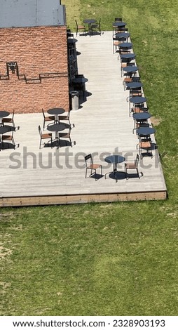 The shadows created by the sunlight hitting the customer tables of a restaurant serving visitors behind the historical walls of Istanbul, offering aesthetic and perspective Royalty-Free Stock Photo #2328903193