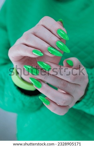 Female hand with long nails, neon green manicure