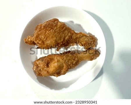 Two fried chicken thighs are arranged on a plate ready to be served.