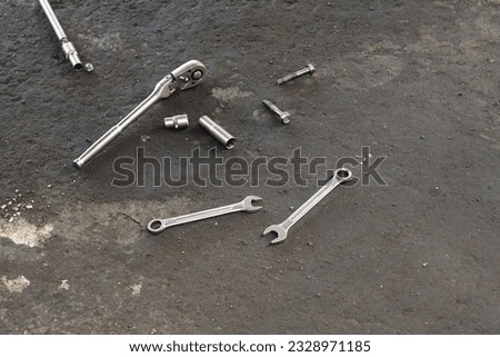 Spanners, nuts and bolts on the floor of the workshop.