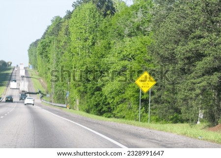 Interstate highway 85 road with sign Caution Bridge May Ice in Winter in city of Atlanta, Georgia with cars driving on commute Royalty-Free Stock Photo #2328991647