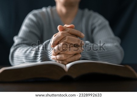 Woman engaged in prayer. In the quiet darkness of a sacred room, she seeks solace, spiritual connection. Immerse yourself in the tranquility and mindfulness of this profound moment.