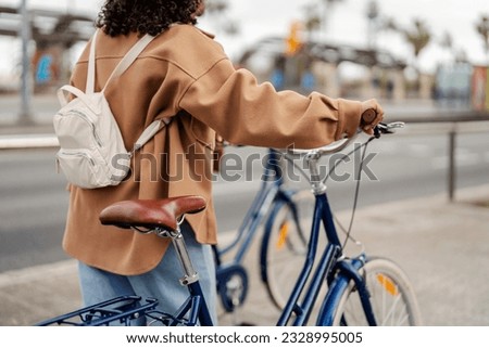 Cut off picture of an unrecognizable girl with bike on the city street.