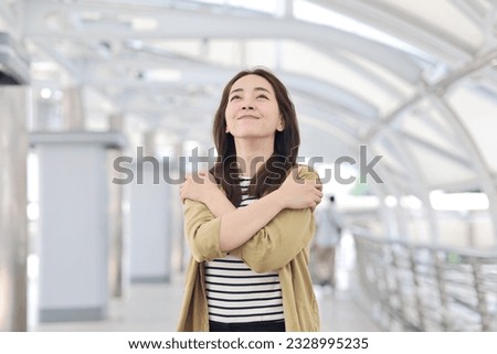 Beautiful Asian woman in casual style standing hugging herself ,Positive self love and self care concept. Royalty-Free Stock Photo #2328995235