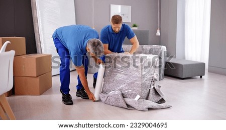 Professional Furniture Movers Wrapping. House Packing Service Royalty-Free Stock Photo #2329004695