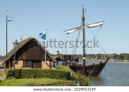 Replica of an old merchant ship -Kamper Kogge,  along the river IJssel near the Dutch historic Hanseatic city of Kampen in Overijssel. Royalty-Free Stock Photo #2329053239