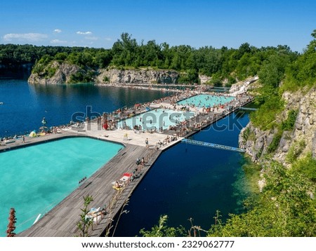 Krakow, Poland - July 8, 2023: Swimming and paddling pools on a Zakrzowek lake with steep cliffs in place of former flooded limestone quarry. Newly opened recreational place with a crowd of people Royalty-Free Stock Photo #2329062777