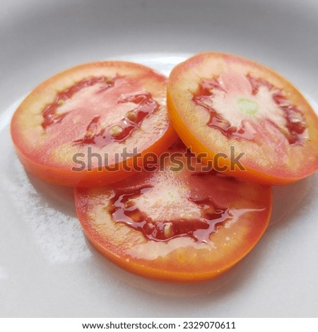 The picture of tomatoes arranged on a plate looks very appetizing.

