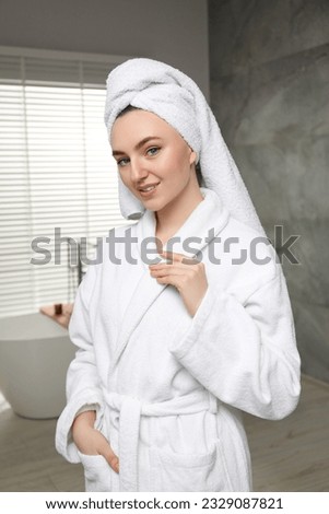 Beautiful woman wearing white robe in bathroom Royalty-Free Stock Photo #2329087821