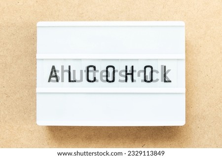 Lightbox with word alochol on wood background