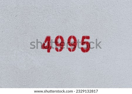 Red Number 4995 on the white wall. Spray paint.
