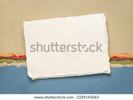 small sheet of blank white Khadi rag paper from India against abstract landscape in earth and blue tones