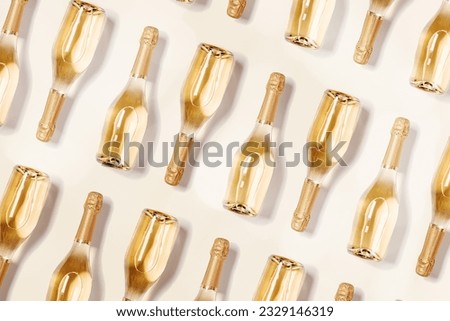 Minimal food pattern with bottles of white sparkling wine, full glass champagne bottles close up on beige. Summer alcohol drink concept. Celebrate holidays, happy summer party monochrome background Royalty-Free Stock Photo #2329146319