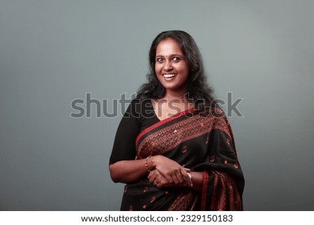 Portrait of a woman of Indian origin wearing traditional dress Sari with a surprised face expression Royalty-Free Stock Photo #2329150183